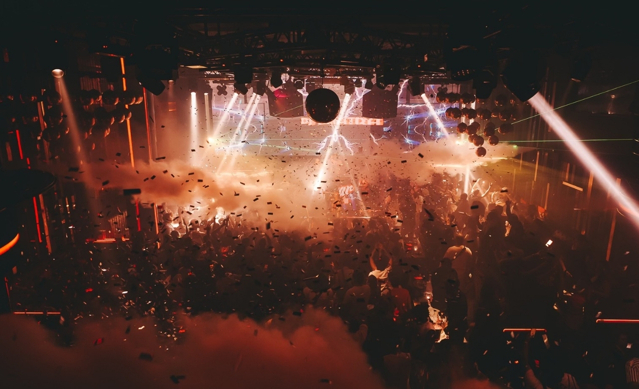 Vibrant neon lights and dancing crowd at a Phuket party